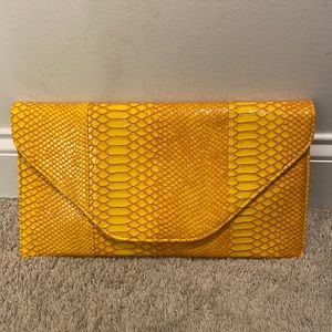 A mustard yellow clutch purse.